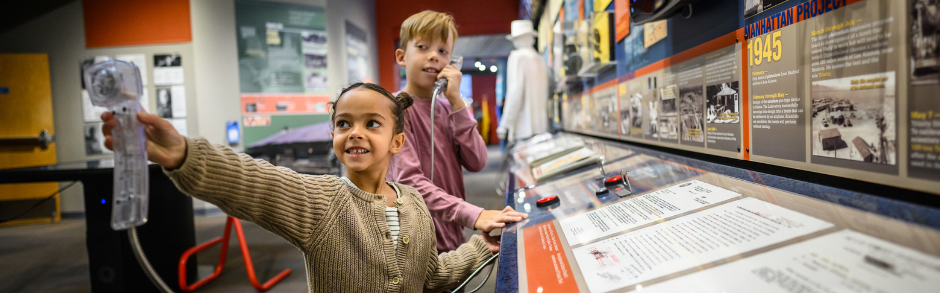 Two children at Bradbury Science Museum interacting with audio exhibit