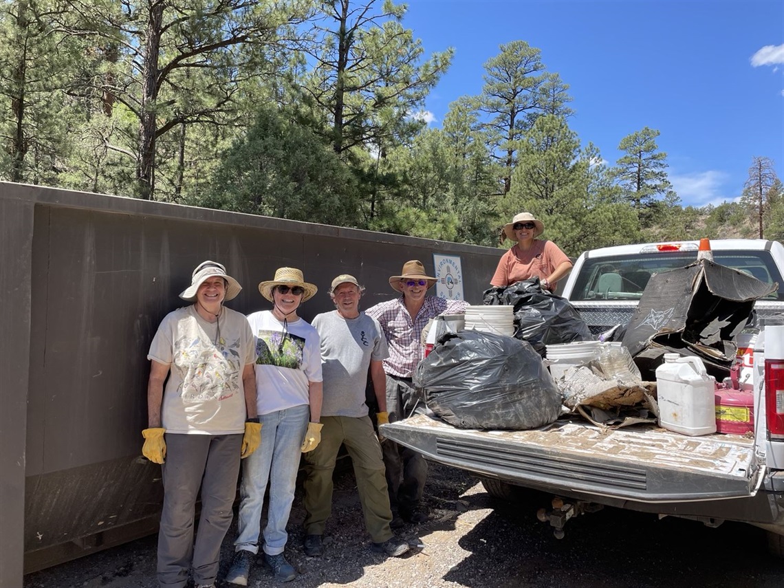 Aug 2023 Trail Clean-up Volunteers standing by a truckload of trash and cleaned-up materials